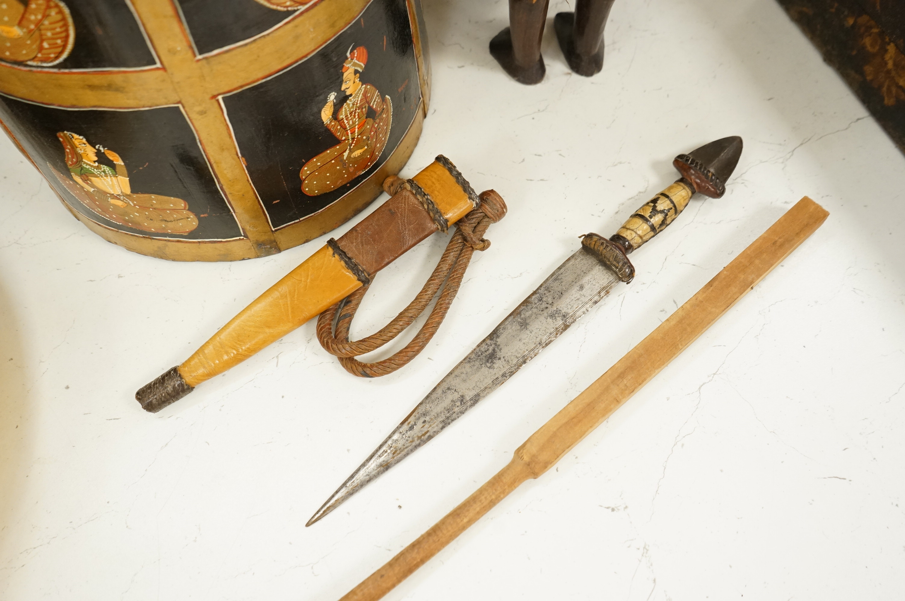 A collection of tribal and Asian collectables including a Tibetan prayer wheel, carvings, etc.